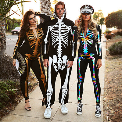 shop halloween - models wearing women's gold skeleton bodysuit, women's iridescent skeleton bodysuit, and men's skeleton costume