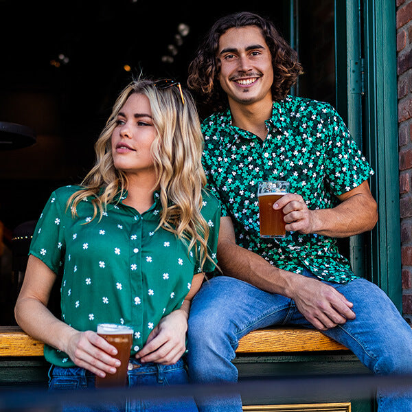 shop st. patrick's day - models wearing men's clover confetti button down shirt and women's simple clover button down shirt