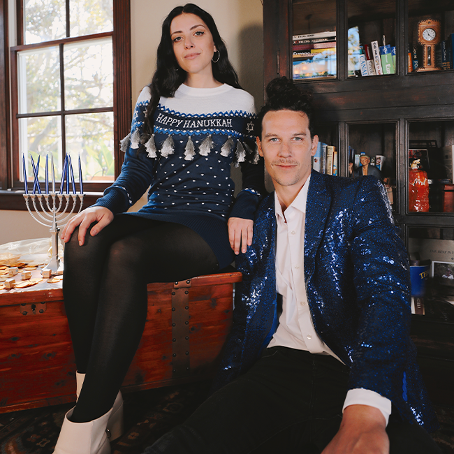 shop hanukkah - image of models wearing women's happy hanukkah tassel sweater dress and men's blue sequin blazer