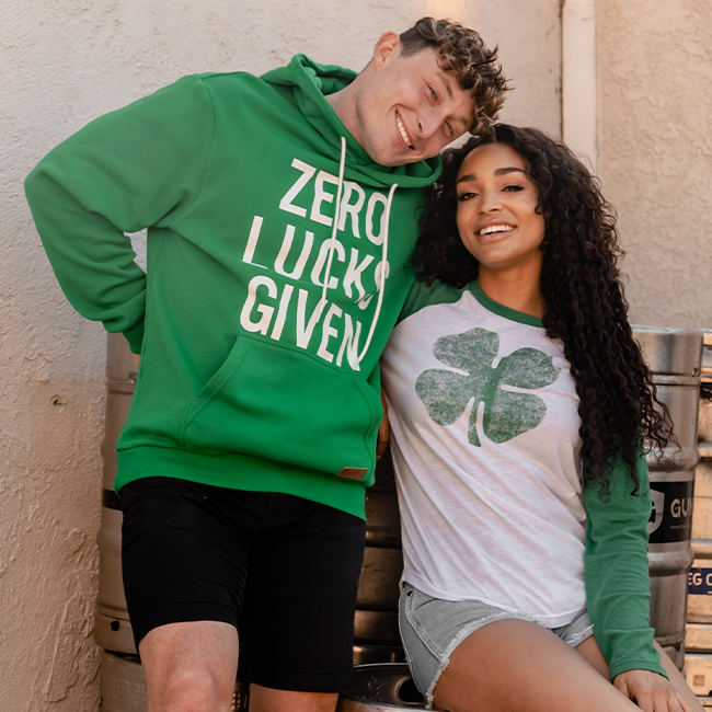 shop st. Patrick's day - models wearing men's zero lucks given hoodie and women's lucky clover long sleeve shirt