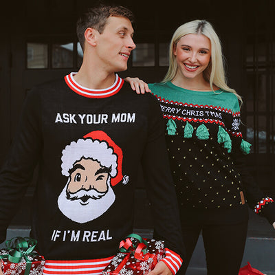shop ugly christmas sweaters - models wearing men's ask your mom ugly christmas sweater and women's christmas tree tassel ugly christmas sweater