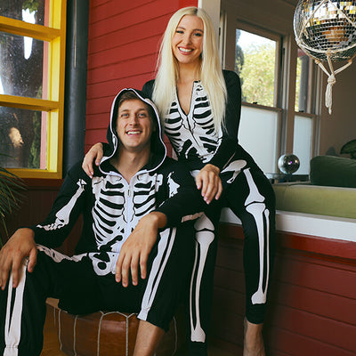 shop halloween - models wearing men's skeleton jumpsuit and women's skeleton bodysuit costumes