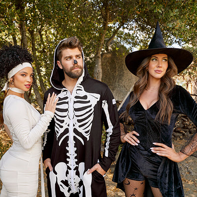shop halloween - models wearing women's mummy bodysuit, men's skeleton costume, and women's witch costume