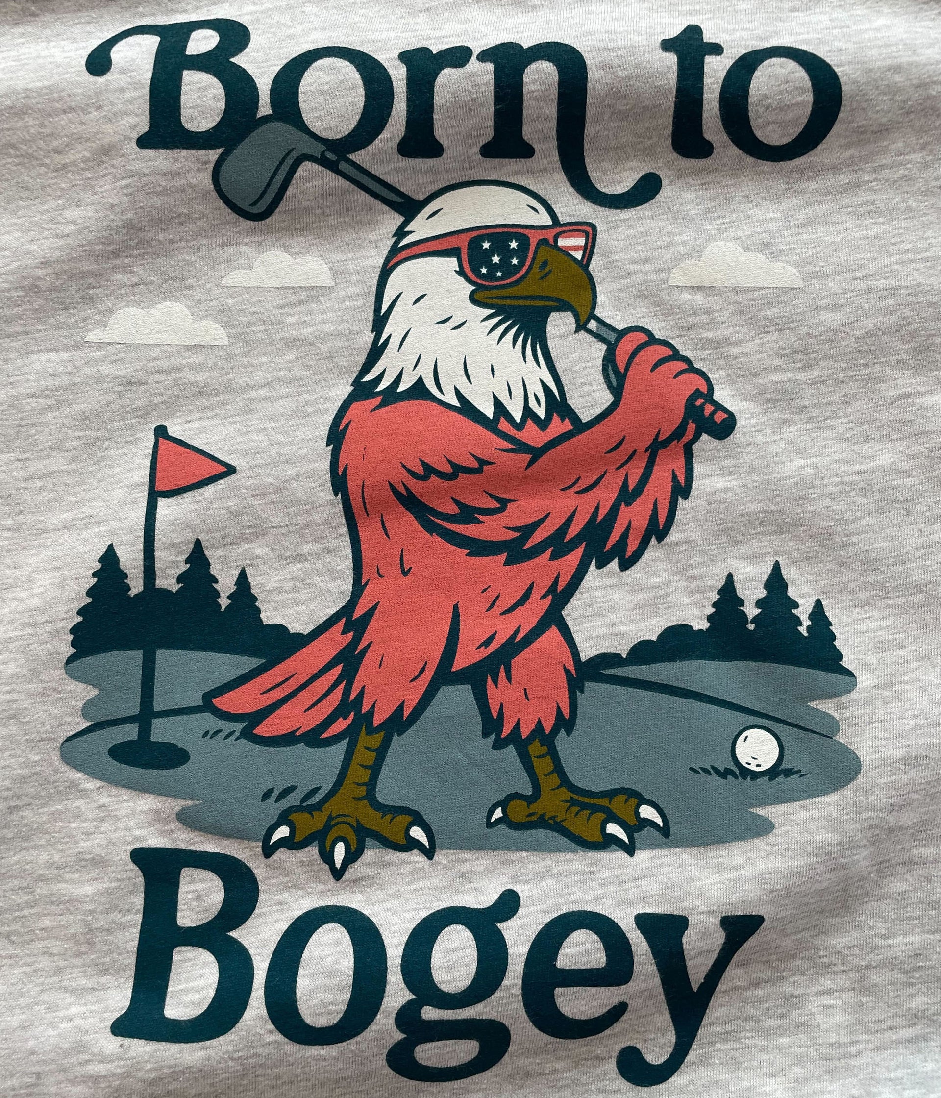 Eagle holding a golf club with text 'Born to Bogey' on a gray background