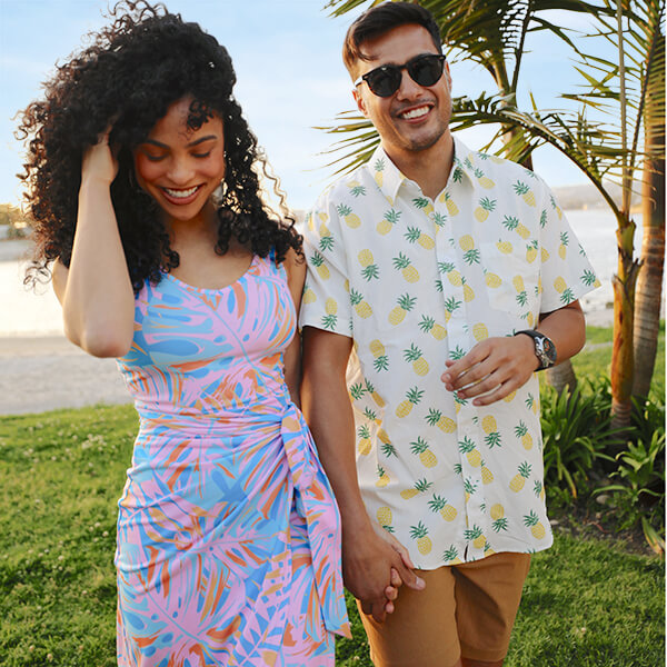 shop vacation - image of models wearing women's palm passionfruit midi dress and men's pineapple parade hawaiian shirt