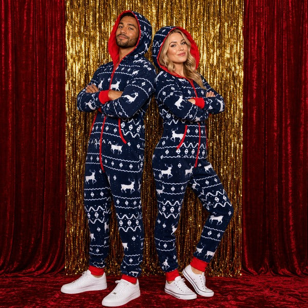 Couple in matching navy Fair Isle reindeer Christmas onesies