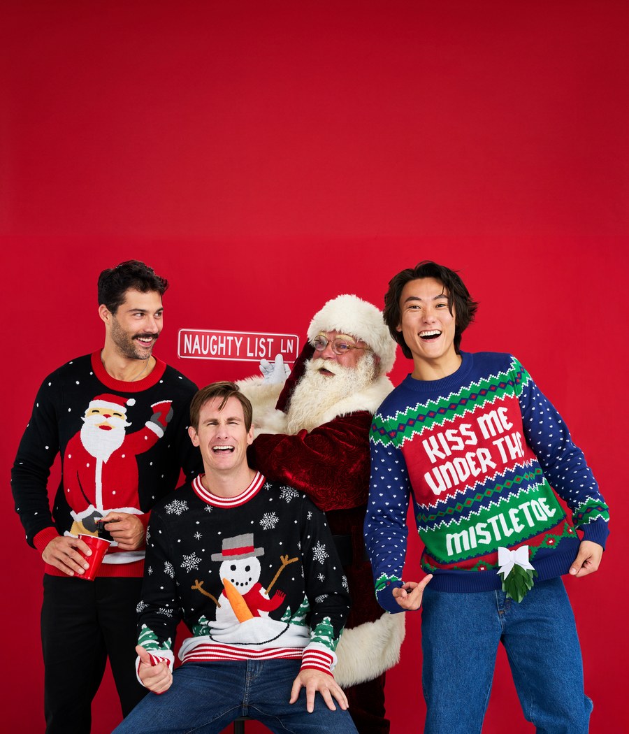 Men in ugly Christmas sweaters posing with Santa