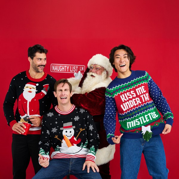 Men in ugly Christmas sweaters posing with Santa