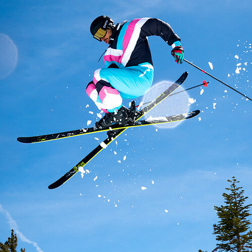 shop ski and snowboard suits - image of man skiing and wearing a ski suit