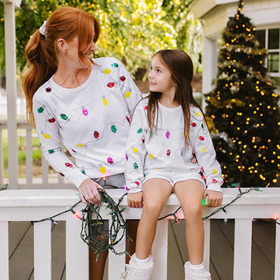 shop christmas - image of a woman and a kid wearing sequin lights sweater