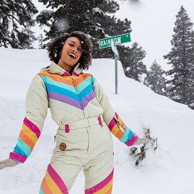 shop ski + snow - image of woman wearing retro rainbow snow suit